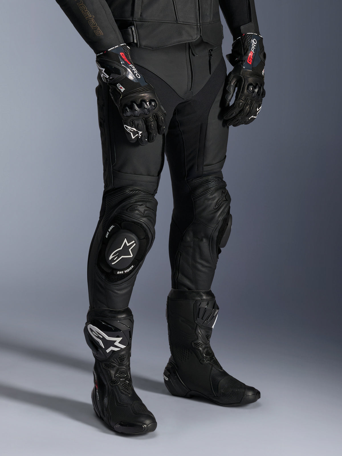 Pantalon en cuir Missile V3, pantalon de course moto noir, porté avec des gants GP Pro assortis et des bottes de course techniques, construction en cuir de première qualité avec sliders de genou à logo blanc, esthétique de course professionnelle pour usage sur piste et sur route