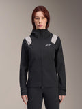 Alpinestars Stella A-Dura Rain Jacket, veste de pluie de cyclisme pour femme, noire avec empiècements gris clair sur les épaules, veste technique à capuche avec logo blanc sur la poitrine, poignets réglables par Velcro, équipement professionnel pour le VTT et le cyclisme par temps humide