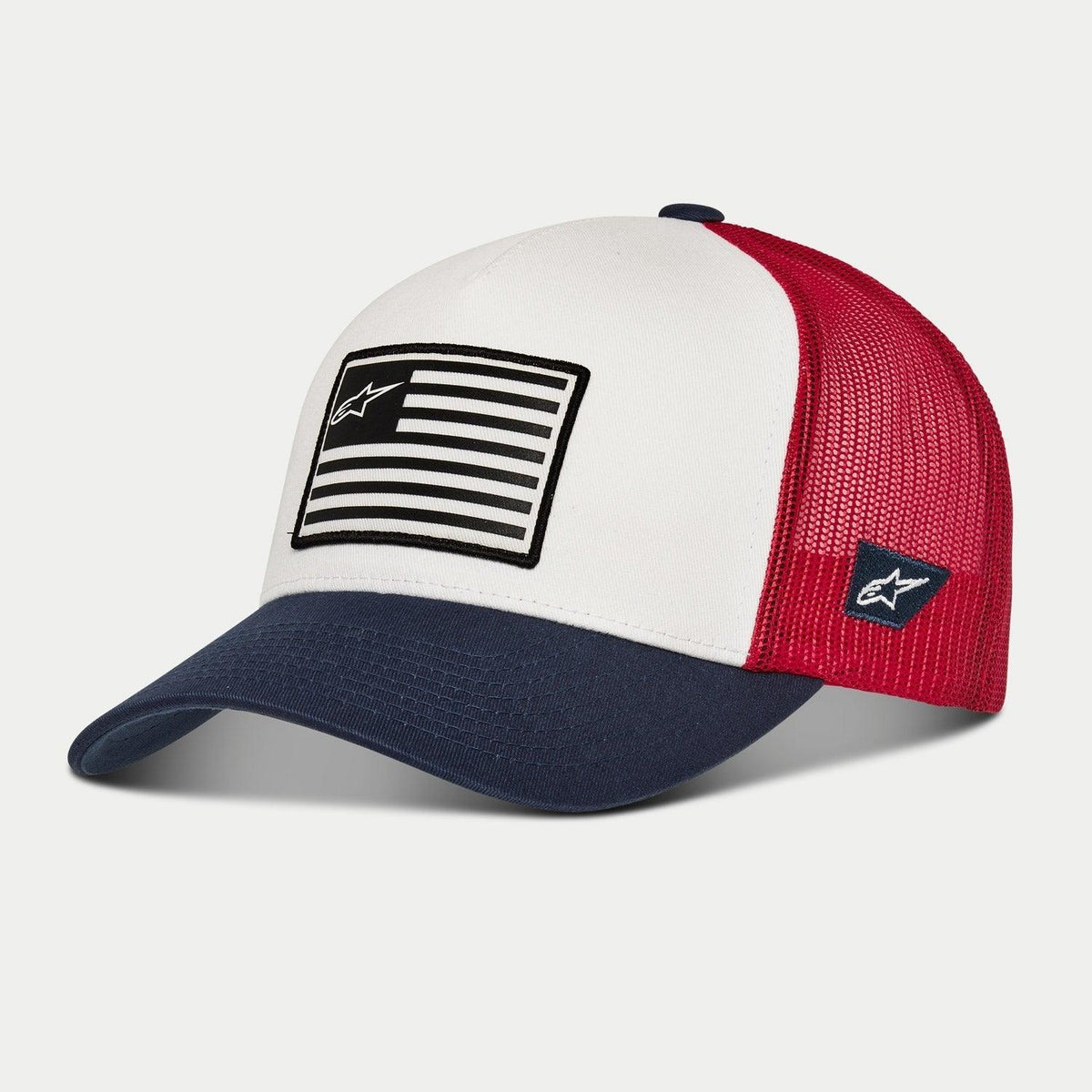 Casquette Snapback Flag Alpinestars, blanc, bleu marine et rouge, casquette de style trucker avec visière incurvée bleu marine, panneau avant blanc structuré orné d'un patch inspiré d'un drapeau, et dos en maille rouge, accessoire motorsport décontracté