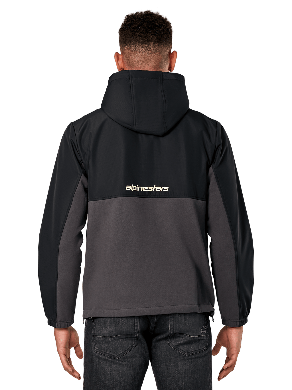 Veste hybride Juncture Alpinestars, vue de dos, noir et gunmetal, anorak sportswear décontracté avec construction en matériaux mixtes, partie supérieure en ripstop et partie inférieure en polaire de toile, logo Alpinestars au dos, porté avec un pantalon sombre
