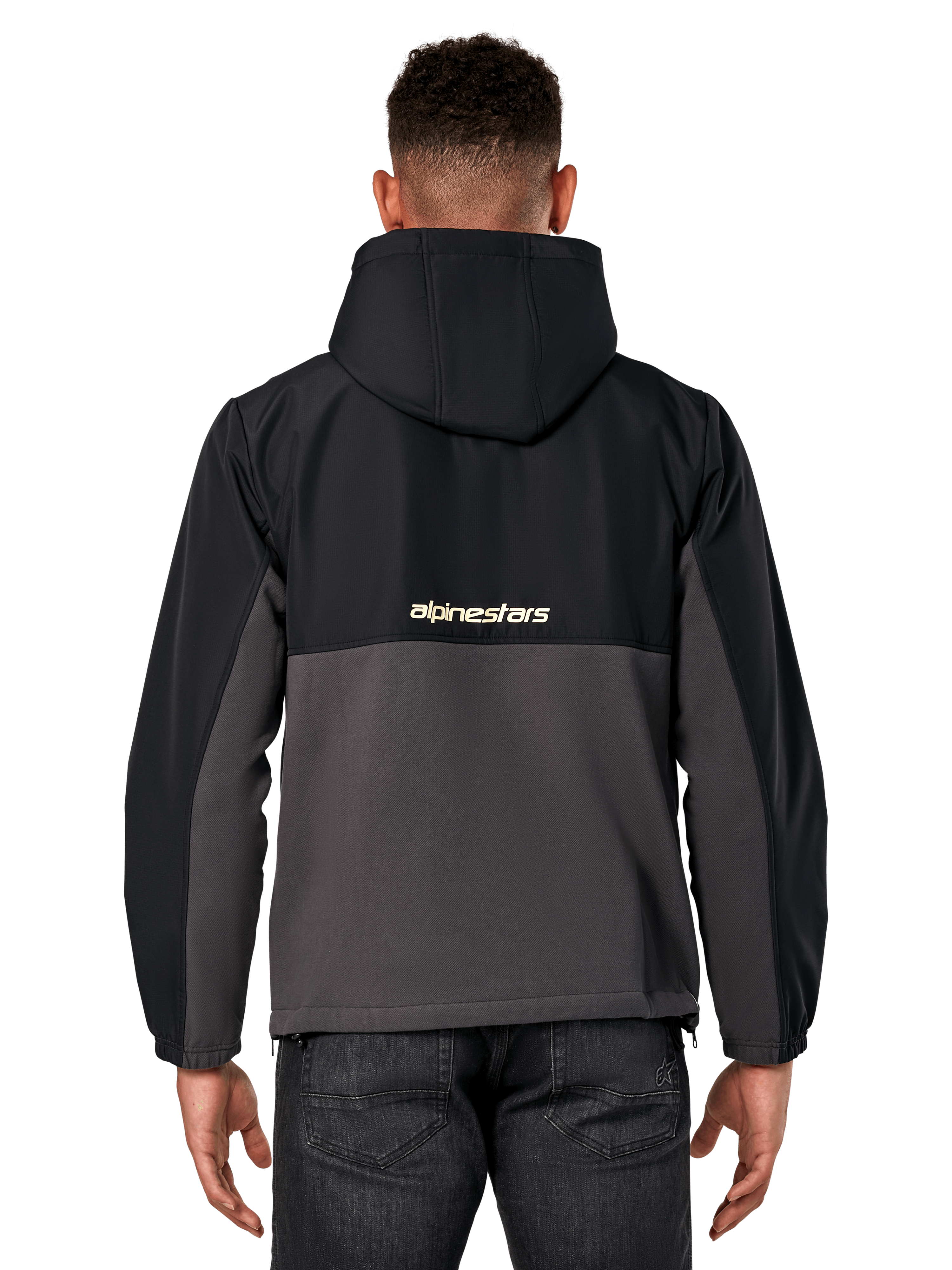 Veste hybride Juncture Alpinestars, vue de dos, noir et gunmetal, anorak sportswear décontracté avec construction en matériaux mixtes, partie supérieure en ripstop et partie inférieure en polaire de toile, logo Alpinestars au dos, porté avec un pantalon sombre
