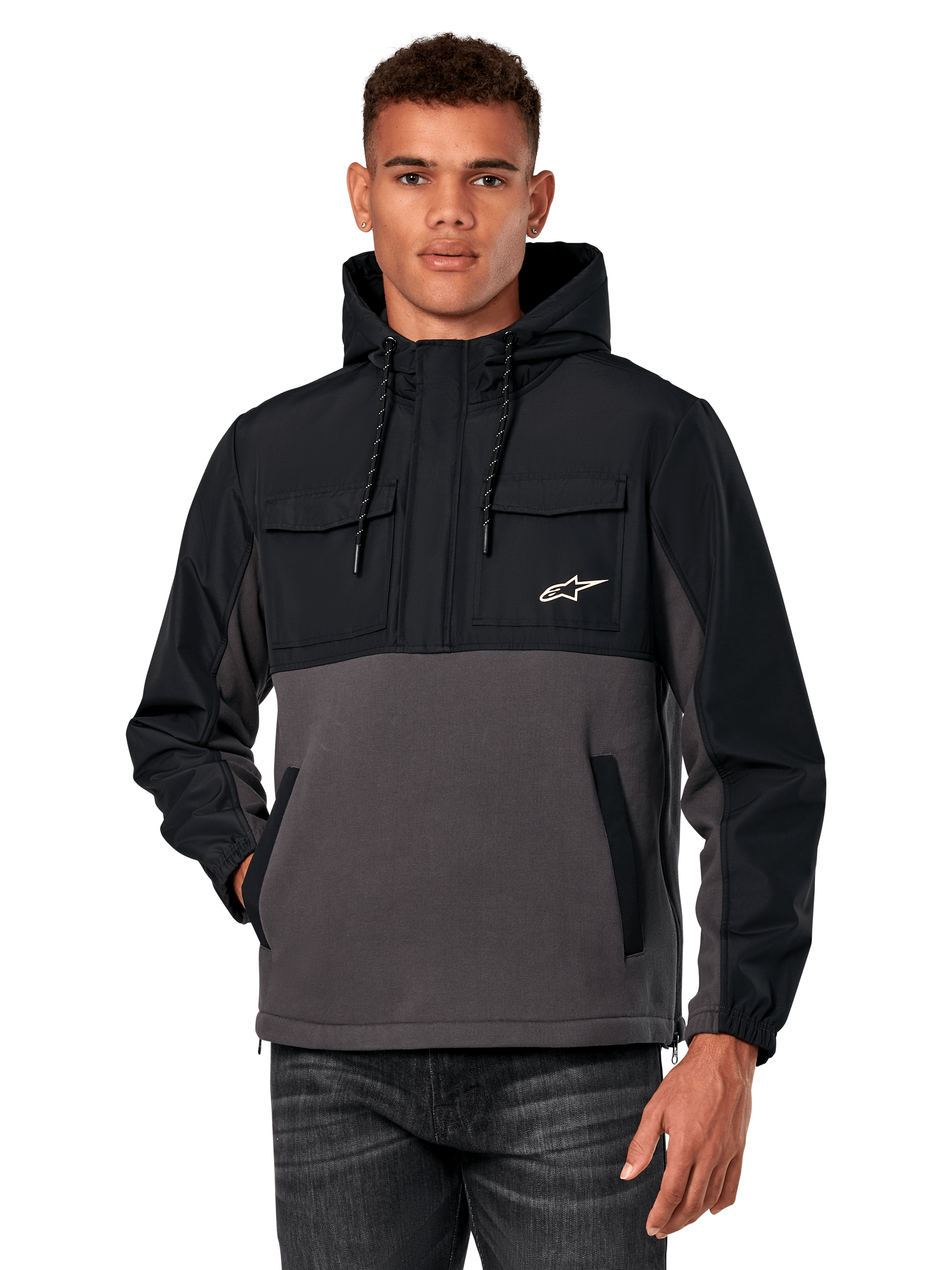 Veste hybride Juncture d'Alpinestars, anorak à capuche pour homme, noir et gris anthracite, design bicolore avec empiècements en ripstop et polaire de toile, poches poitrine avec logo étoile blanc et capuche à cordon de serrage, style streetwear décontracté inspiré des sports mécaniques