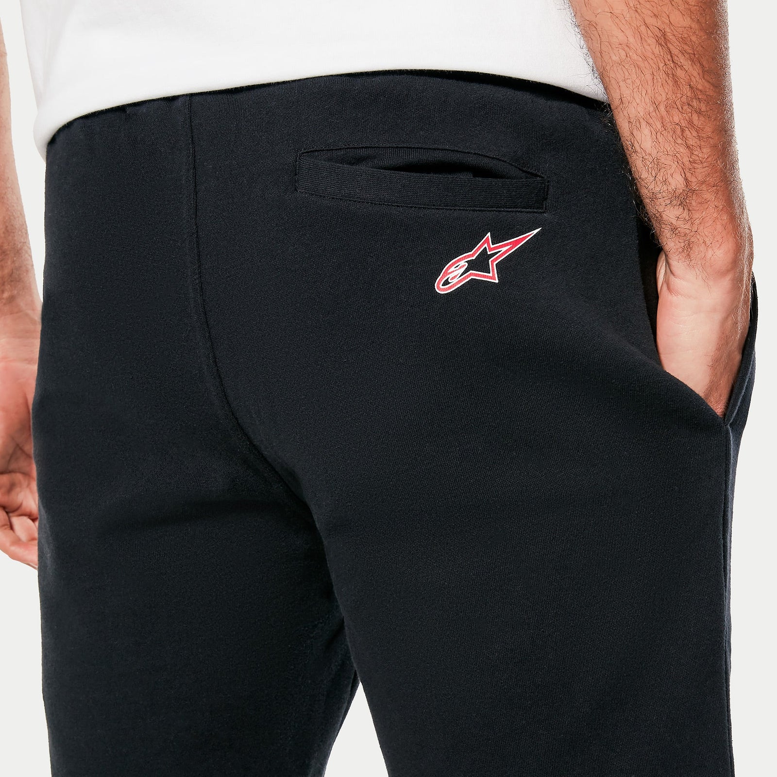 Alpinestars Dunker Short, short d'entraînement noir en polaire, vue rapprochée du logo Ageless rouge et blanc sur la hanche arrière et de la poche arrière passepoilée