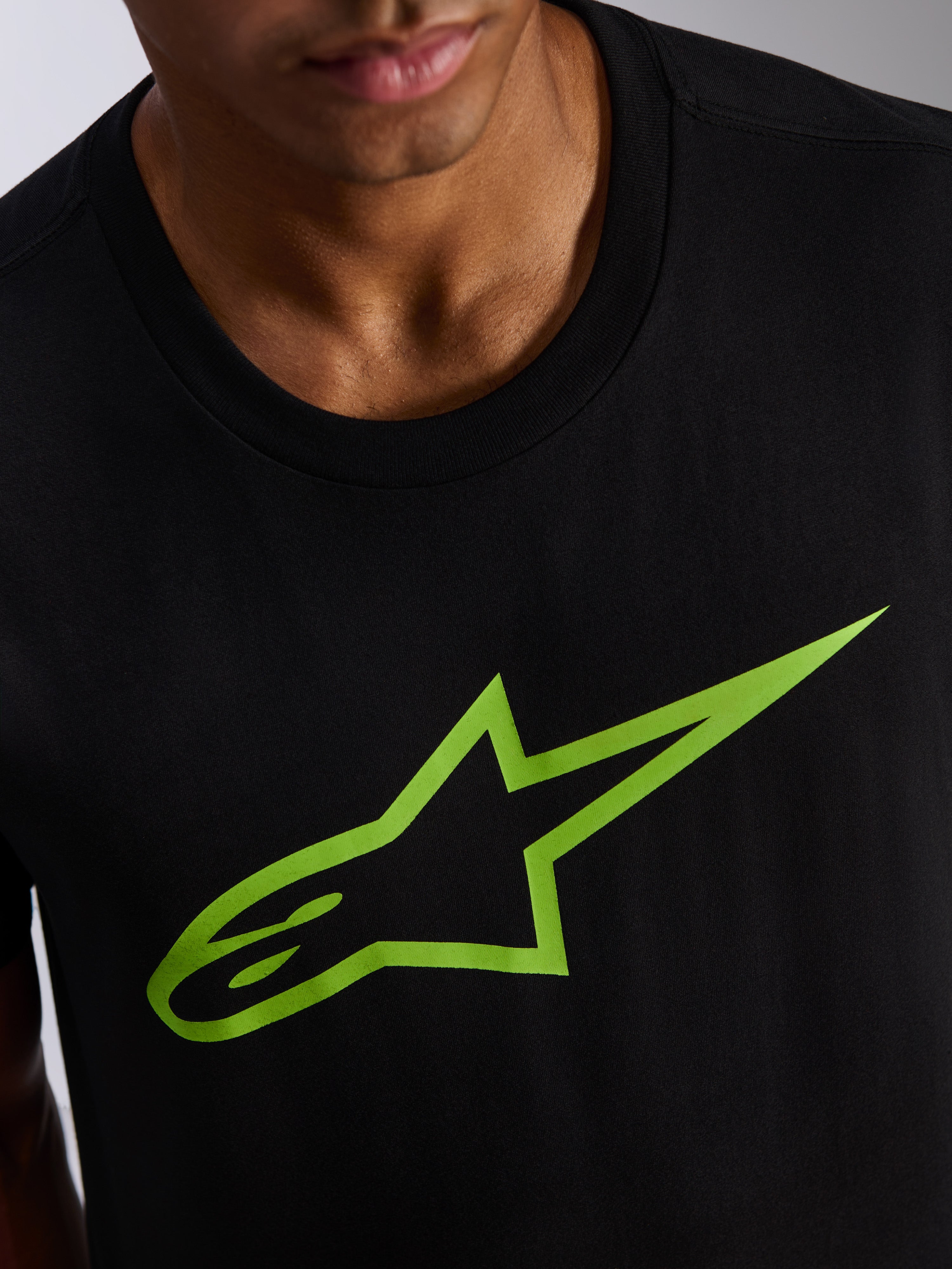 T-shirt Alpinestars Ageless 2.0 CSF, t-shirt à manches courtes, noir avec logo étoile vert vif, gros plan sur le motif de la poitrine et l'encolure, vêtement décontracté de style motorsport streetwear