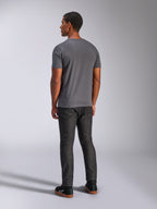 T-shirt Alpinestars Always 2.0 CSF, t-shirt à manches courtes, gris anthracite, vue de dos sur mannequin, associé à un pantalon en jean foncé et des baskets noires, streetwear décontracté inspiré des sports mécaniques