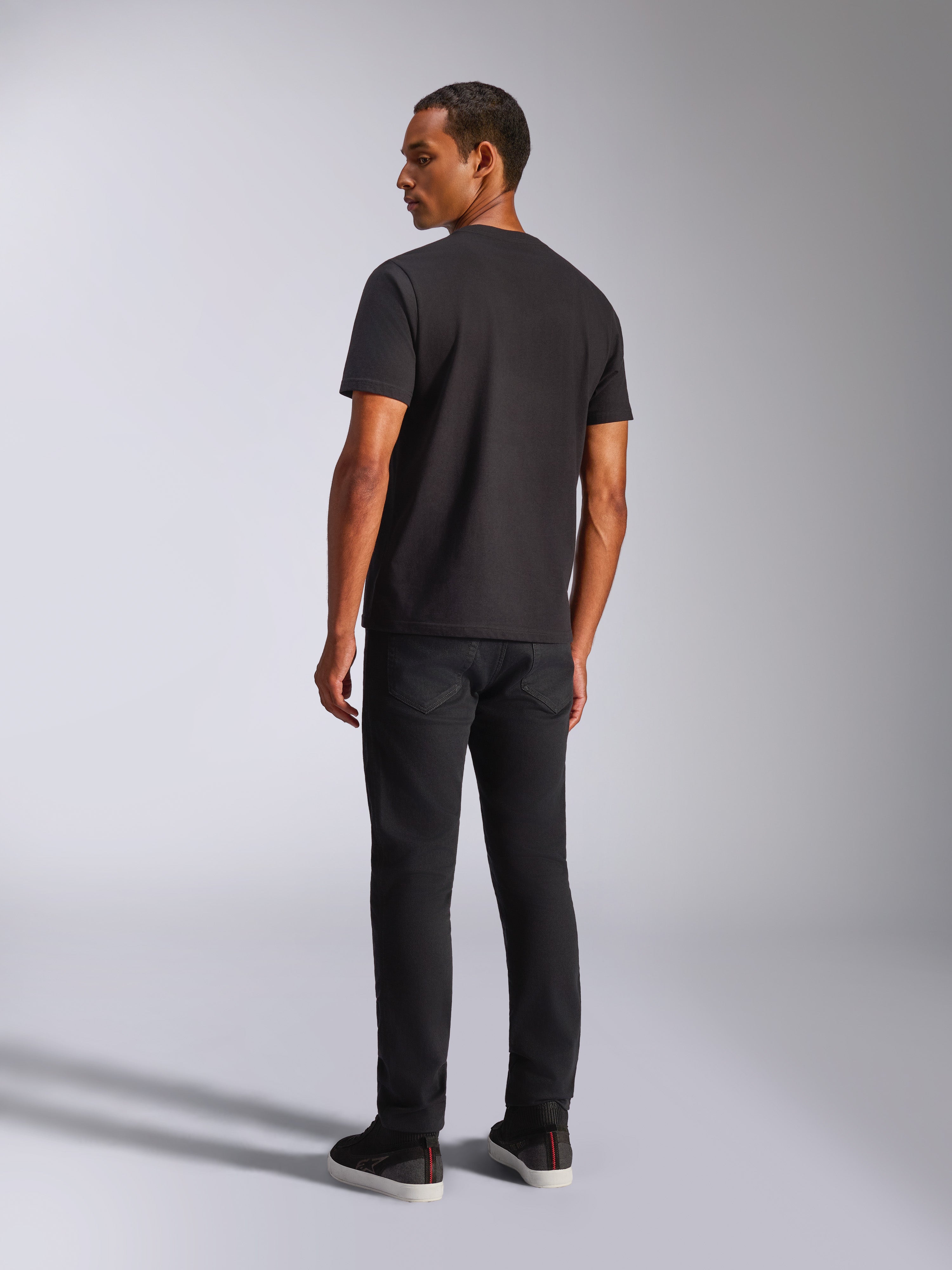 Alpinestars Blaze 2.0 CSF Tee, t-shirt à manches courtes, noir, vue de dos sur un mannequin homme, porté avec un pantalon noir, streetwear motorsport décontracté