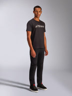 Alpinestars Blaze 2.0 CSF Tee, t-shirt à manches courtes, noir avec logo graphique blanc et gris, porté par un mannequin homme avec pantalon noir et baskets montantes, streetwear motorsport décontracté