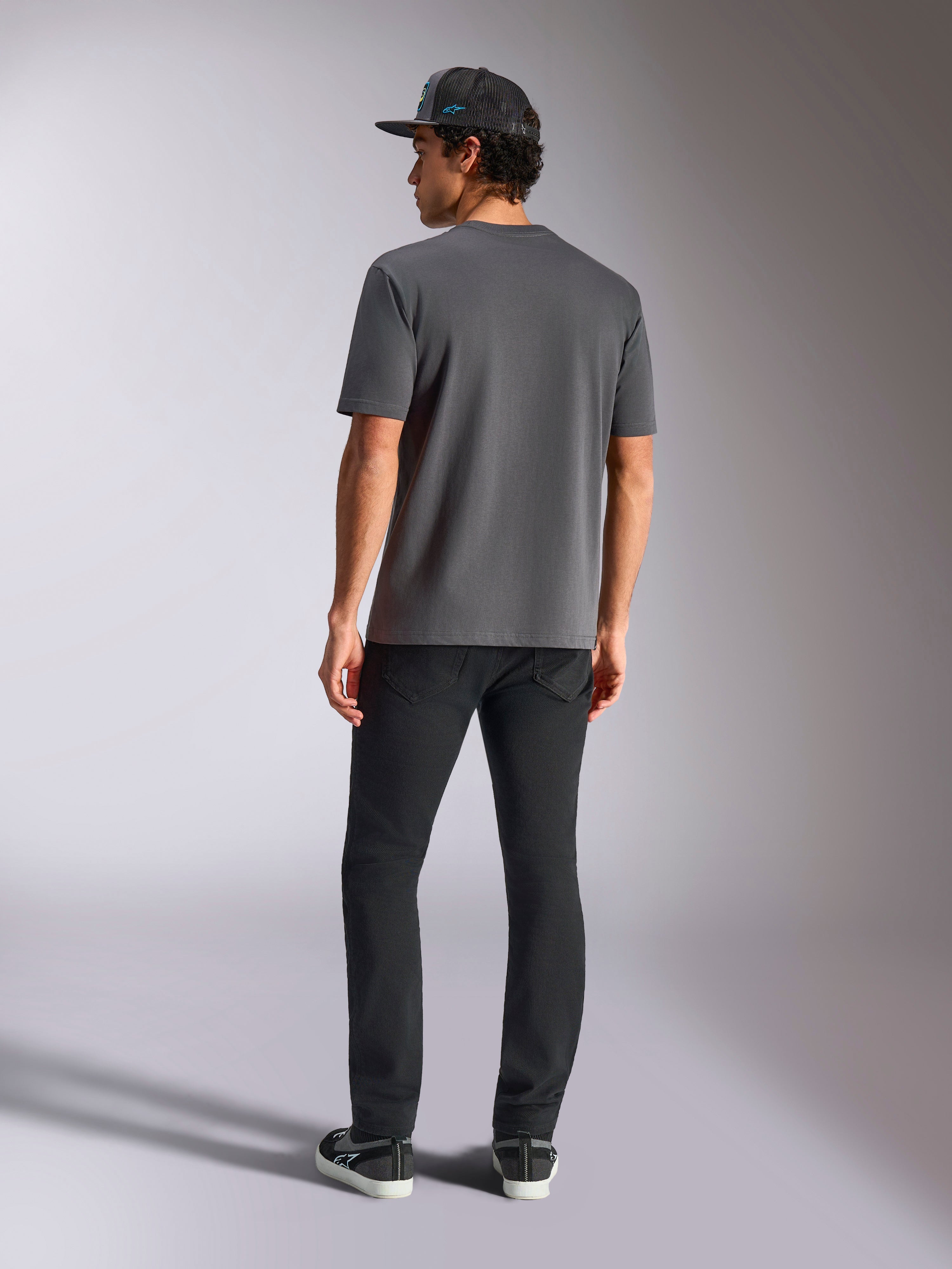Alpinestars Blaze 2.0 CSF Tee, gris anthracite, vue de dos, t-shirt à manches courtes, porté avec un pantalon noir et une casquette en mesh noire, style streetwear décontracté inspiré des sports mécaniques