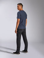 Alpinestars Blaze 2.0 CSF Tee, T-shirt à manches courtes, bleu marine, vue de dos sur modèle, porté avec un pantalon noir et des baskets, streetwear décontracté inspiré par le sport automobile