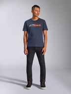 T-shirt Alpinestars Blaze 2.0 CSF, t-shirt à manches courtes, bleu marine avec logo Astars blanc et orange, porté avec un pantalon noir et des baskets noires, streetwear décontracté d'inspiration sport mécanique