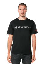 Alpinestars Linear Wordmark 2.0 CSF Tee, T-shirt à manches courtes, noir, mot-symbole linéaire gris sur la poitrine et logo Ageless rouge sur la manche, porté par un mannequin avec un jean foncé, streetwear décontracté inspiré du sport automobile
