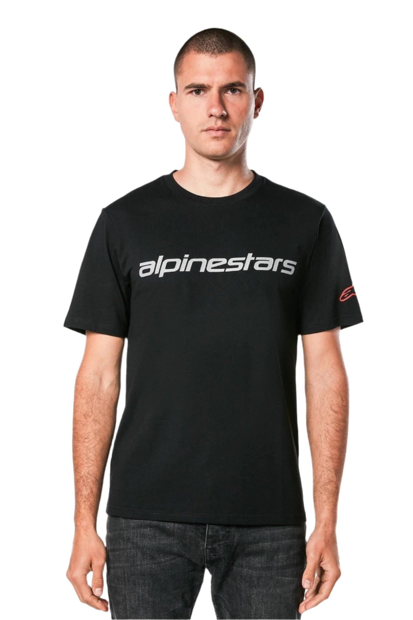 Alpinestars Linear Wordmark 2.0 CSF Tee, T-shirt à manches courtes, noir, mot-symbole linéaire gris sur la poitrine et logo Ageless rouge sur la manche, porté par un mannequin avec un jean foncé, streetwear décontracté inspiré du sport automobile