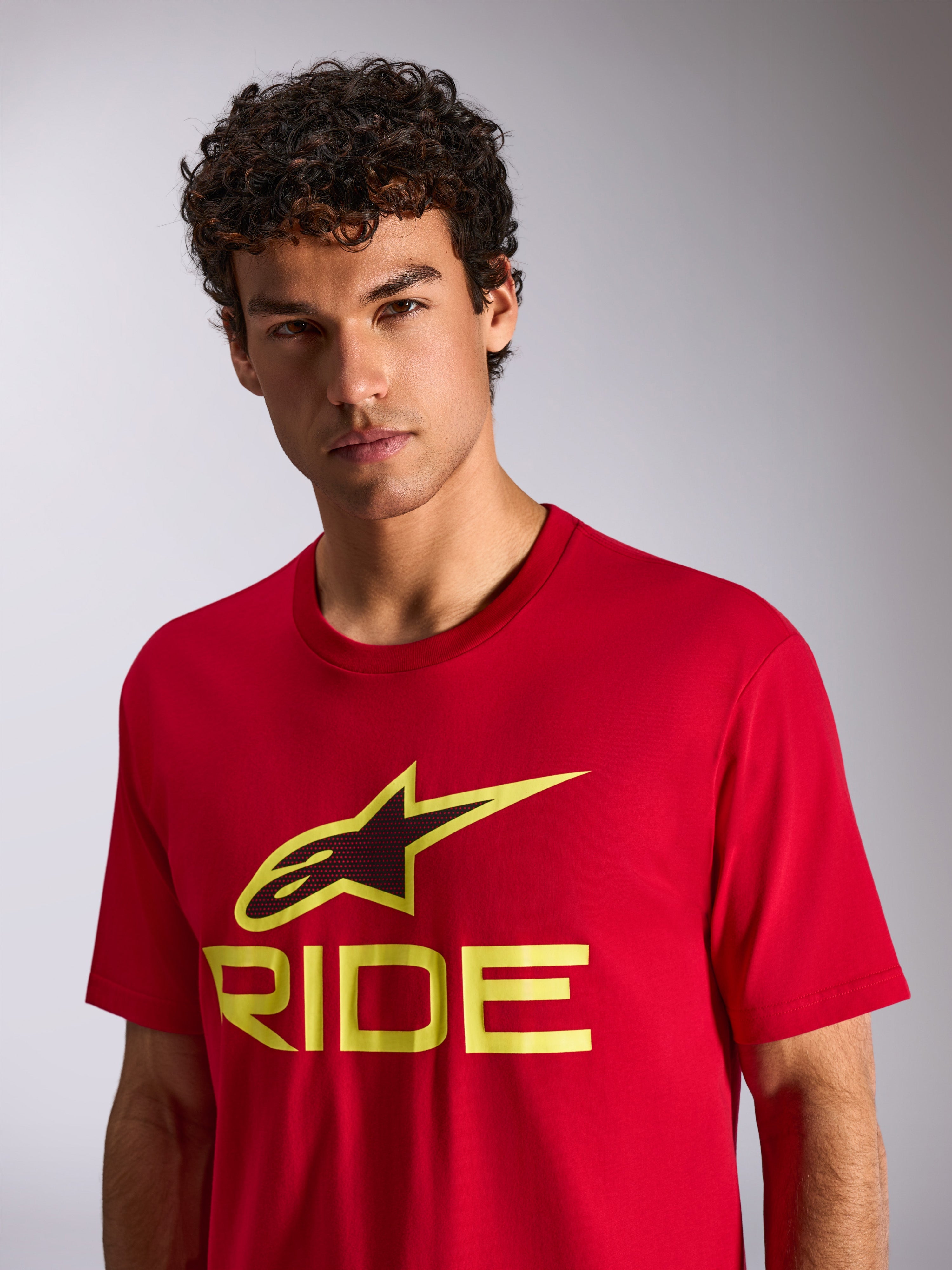 T-shirt Alpinestars Ride 4.0 CSF, t-shirt à manches courtes, rouge avec logo Ride jaune fluo et noir, porté par un mannequin, vêtement streetwear décontracté