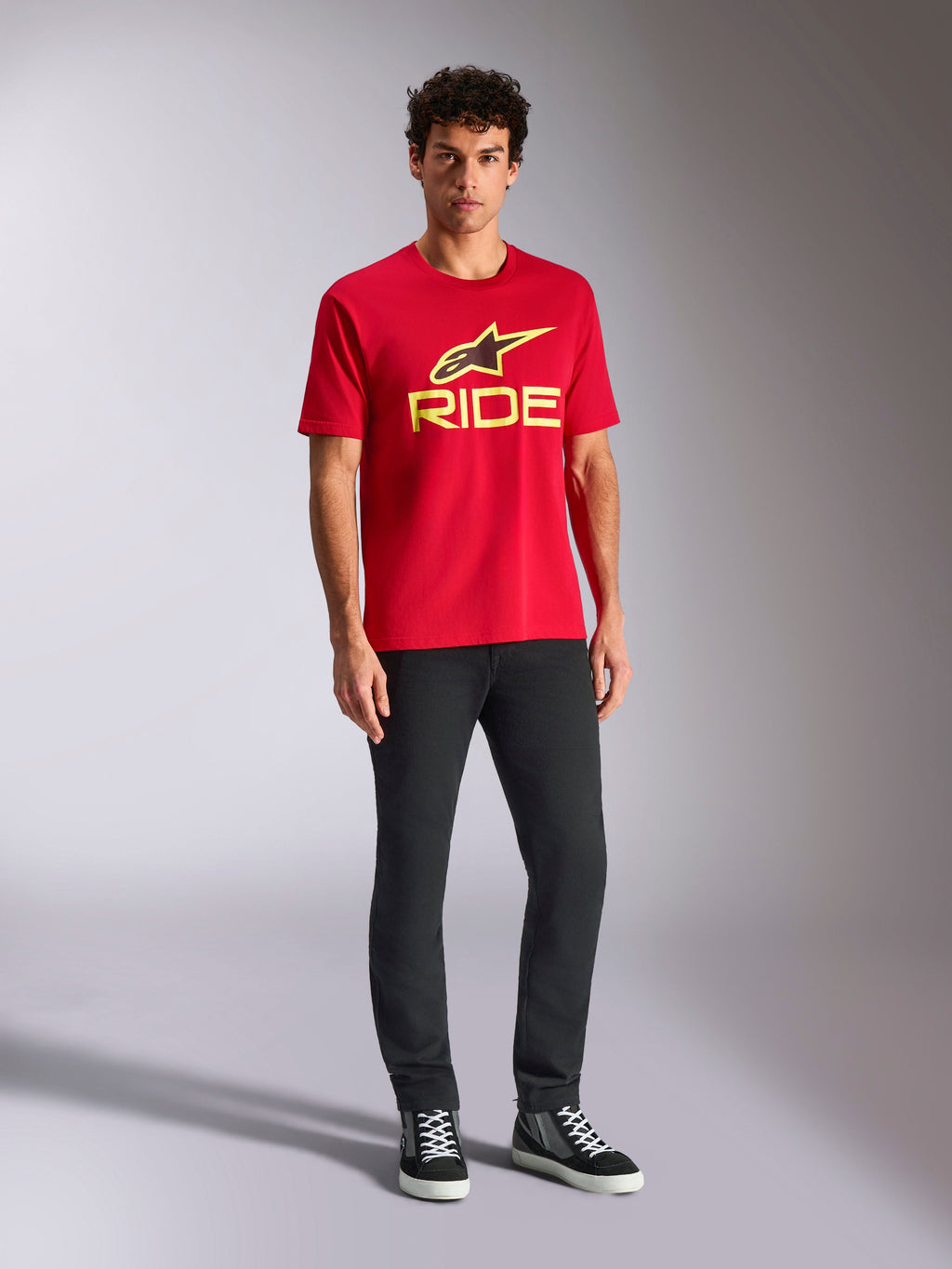 T-shirt Alpinestars Ride 4.0 CSF, t-shirt à manches courtes, rouge avec logo Ride et étoile Alpinestars jaune fluo, porté par un mannequin avec un pantalon noir et des baskets, vêtement sportswear décontracté