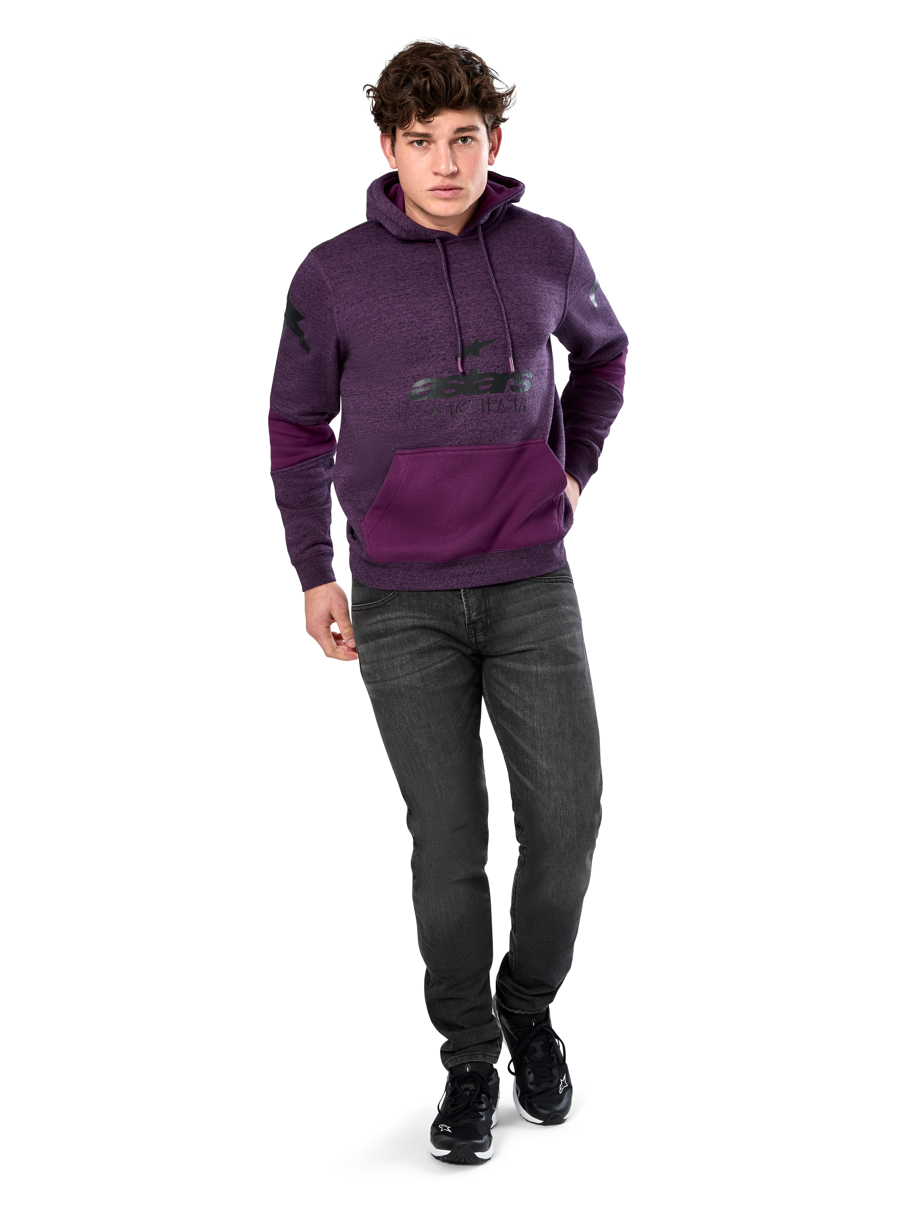 Sweat à capuche Alpinestars Perpetuate, style streetwear décontracté, molleton violet chiné avec empiècements en tissu violet foncé sur la poche kangourou et les manches, logo noir sur la poitrine, capuche à cordon de serrage, porté par un mannequin avec un jean gris foncé et des baskets noires