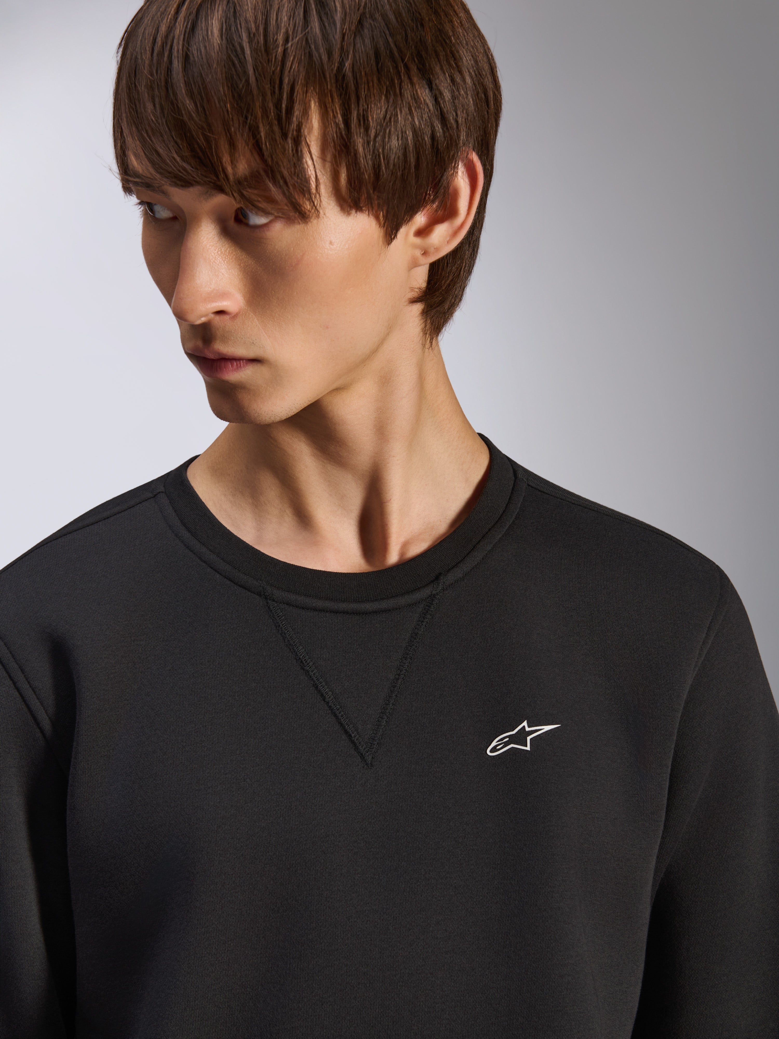 Sweat-shirt Alpinestars Positive Crew, col rond noir avec détail de couture en V au col, petit logo Alpinestars blanc sur la poitrine gauche, streetwear décontracté inspiré du sport automobile