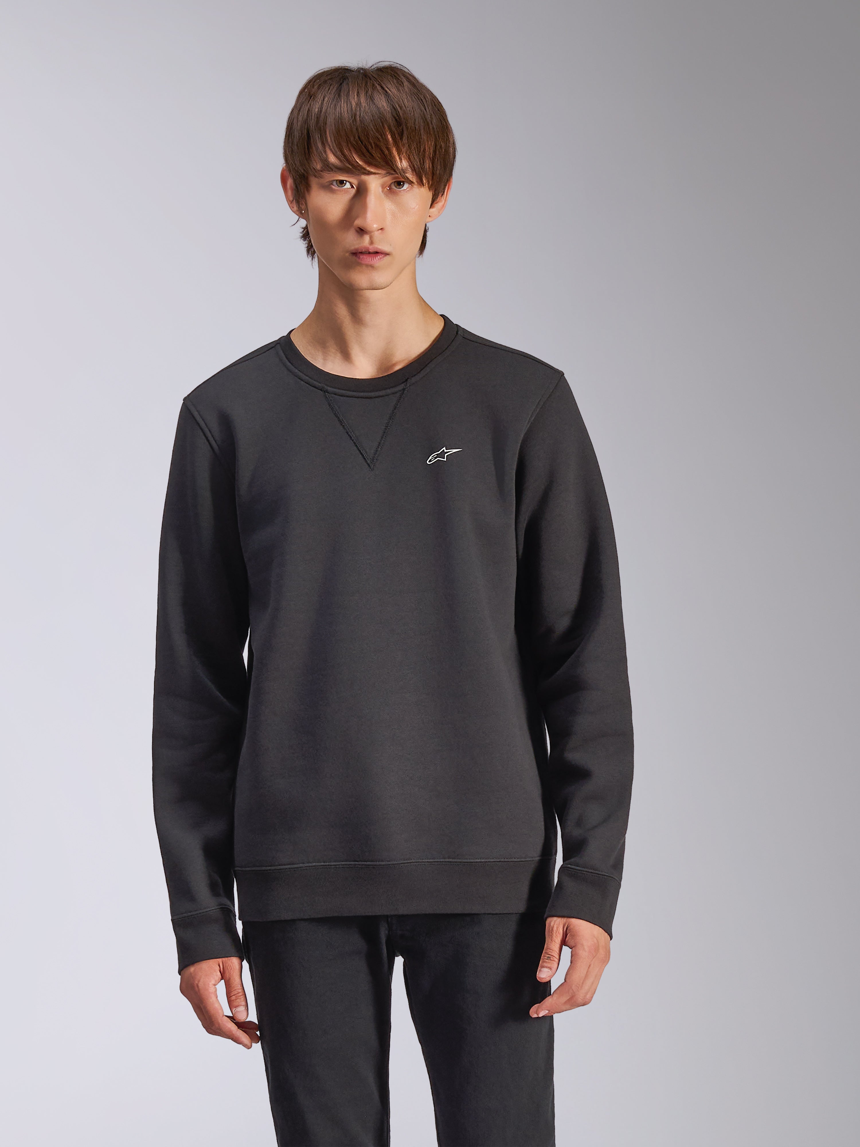 Sweat-shirt Alpinestars Positive Crew, noir, avec un petit logo Alpinestars blanc sur la poitrine, col ras du cou avec détail de couture en V, poignets et ourlet côtelés, streetwear décontracté d'inspiration sport mécanique