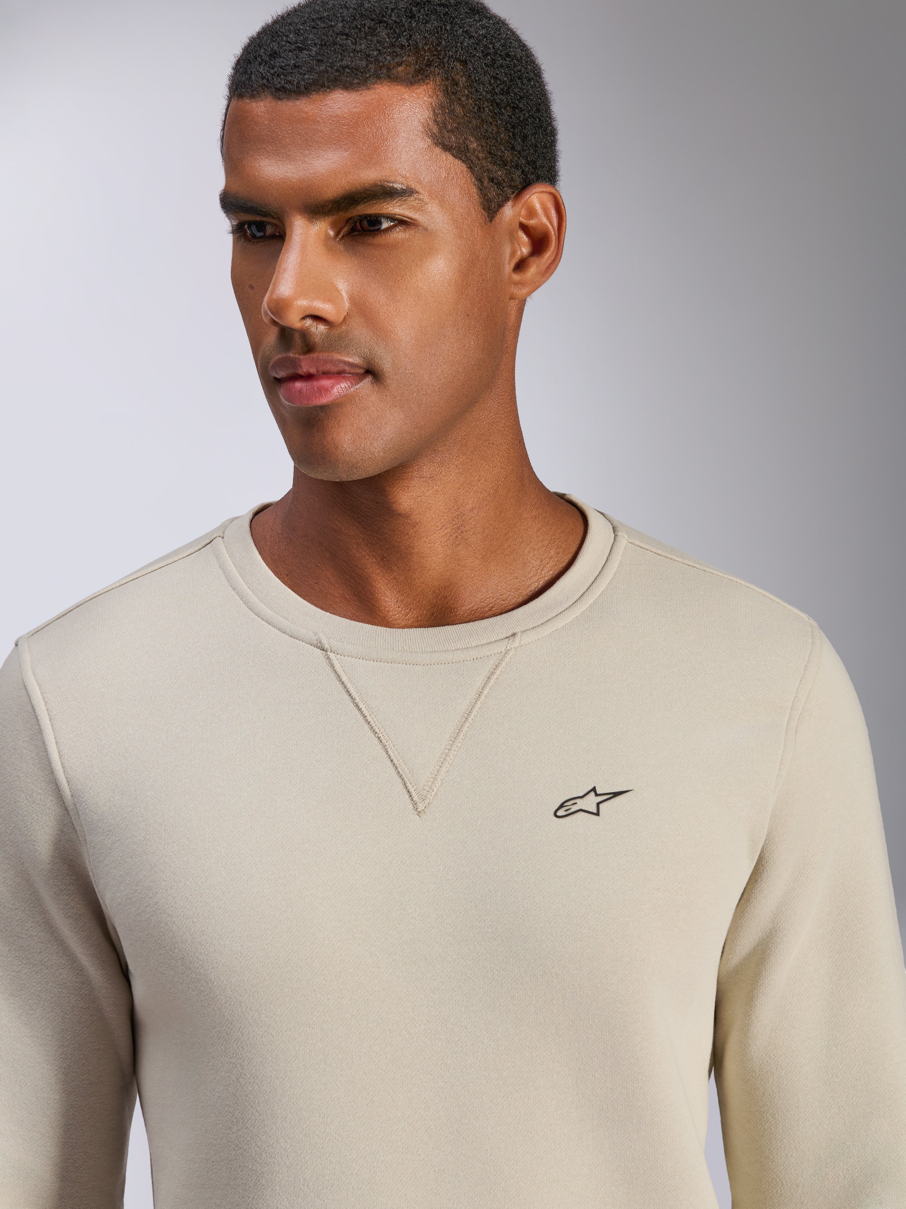 Sweatshirt Alpinestars Positive Crew, blanc cassé, pull à col rond avec petit logo étoile noir sur la poitrine, couture en V à l'encolure, vêtement lifestyle décontracté inspiré du sport automobile