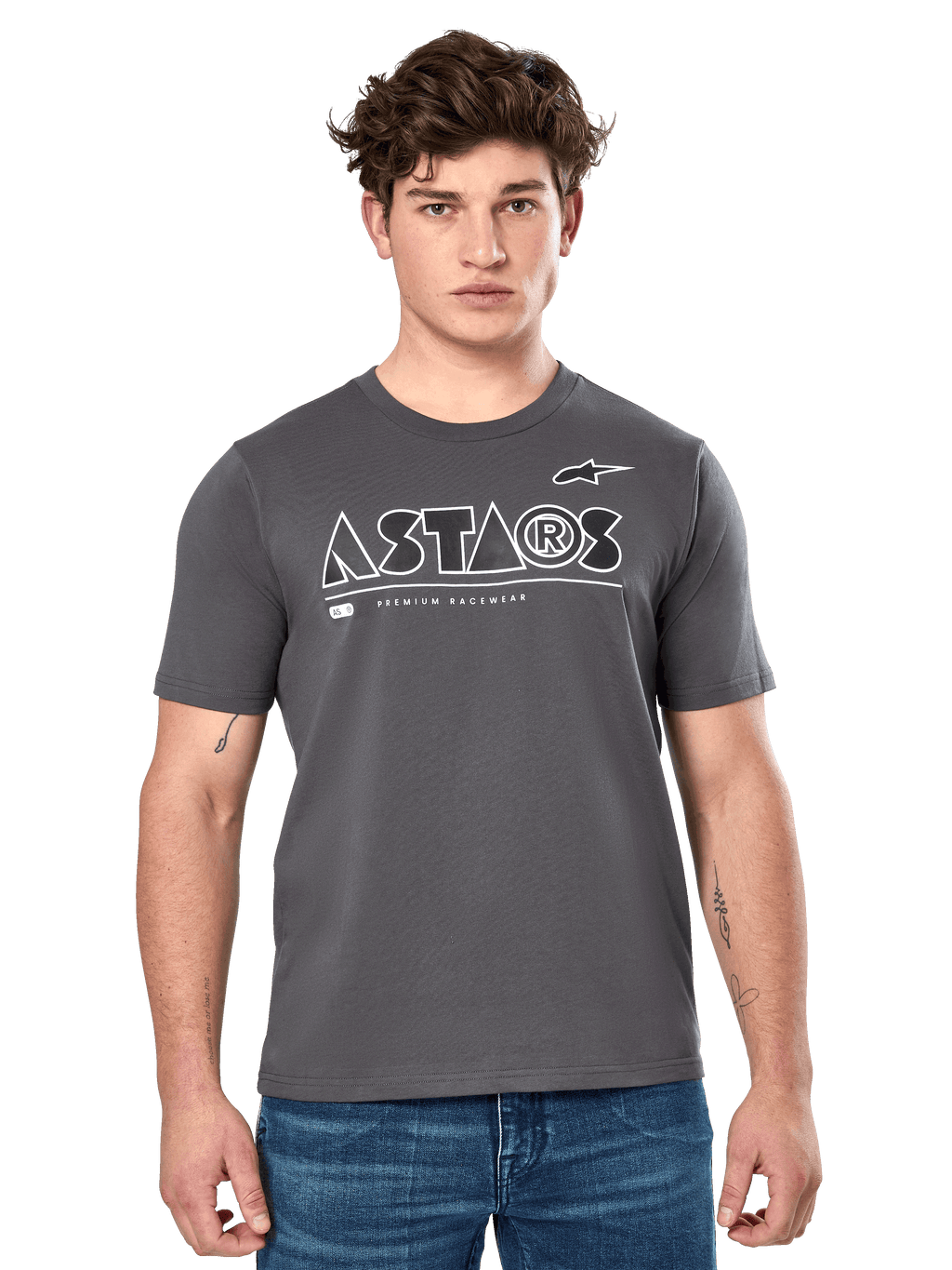 Alpinestars Cereal CSF Tee, t-shirt à manches courtes gris anthracite, porté par un mannequin homme avec un jean bleu, logo géométrique ASTARS blanc et inscription « Premium Racewear », vêtement lifestyle décontracté inspiré du sport automobile