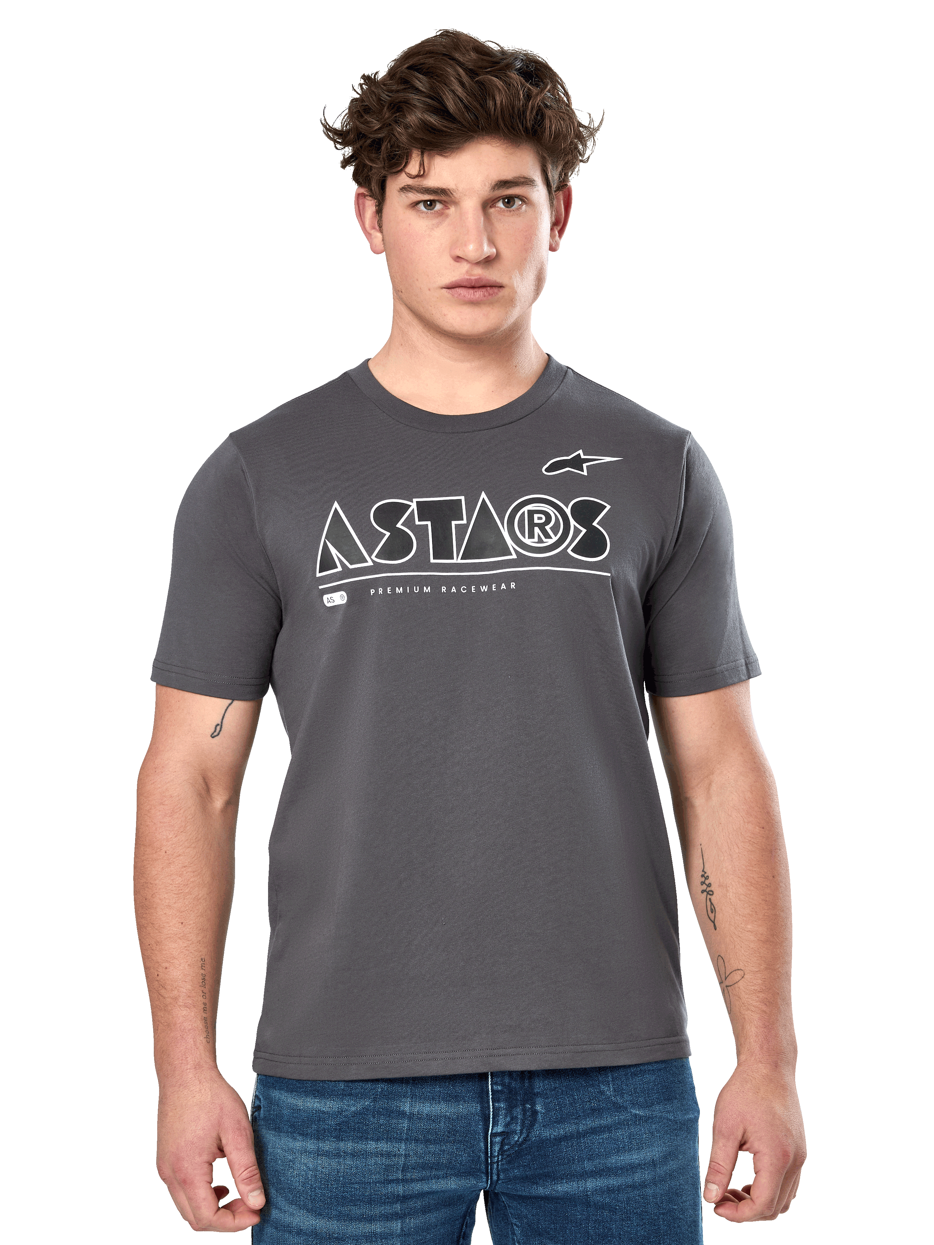 Alpinestars Cereal CSF Tee, t-shirt à manches courtes gris anthracite, porté par un mannequin homme avec un jean bleu, logo géométrique ASTARS blanc et inscription « Premium Racewear », vêtement lifestyle décontracté inspiré du sport automobile