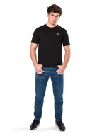 Alpinestars Dot Carbon CSF Tee, Short Sleeve T-Shirt, Black, Small Circular Astars Dot Logo on Chest, worn with blue jeans and black sneakers, casual motorsport streetwear
