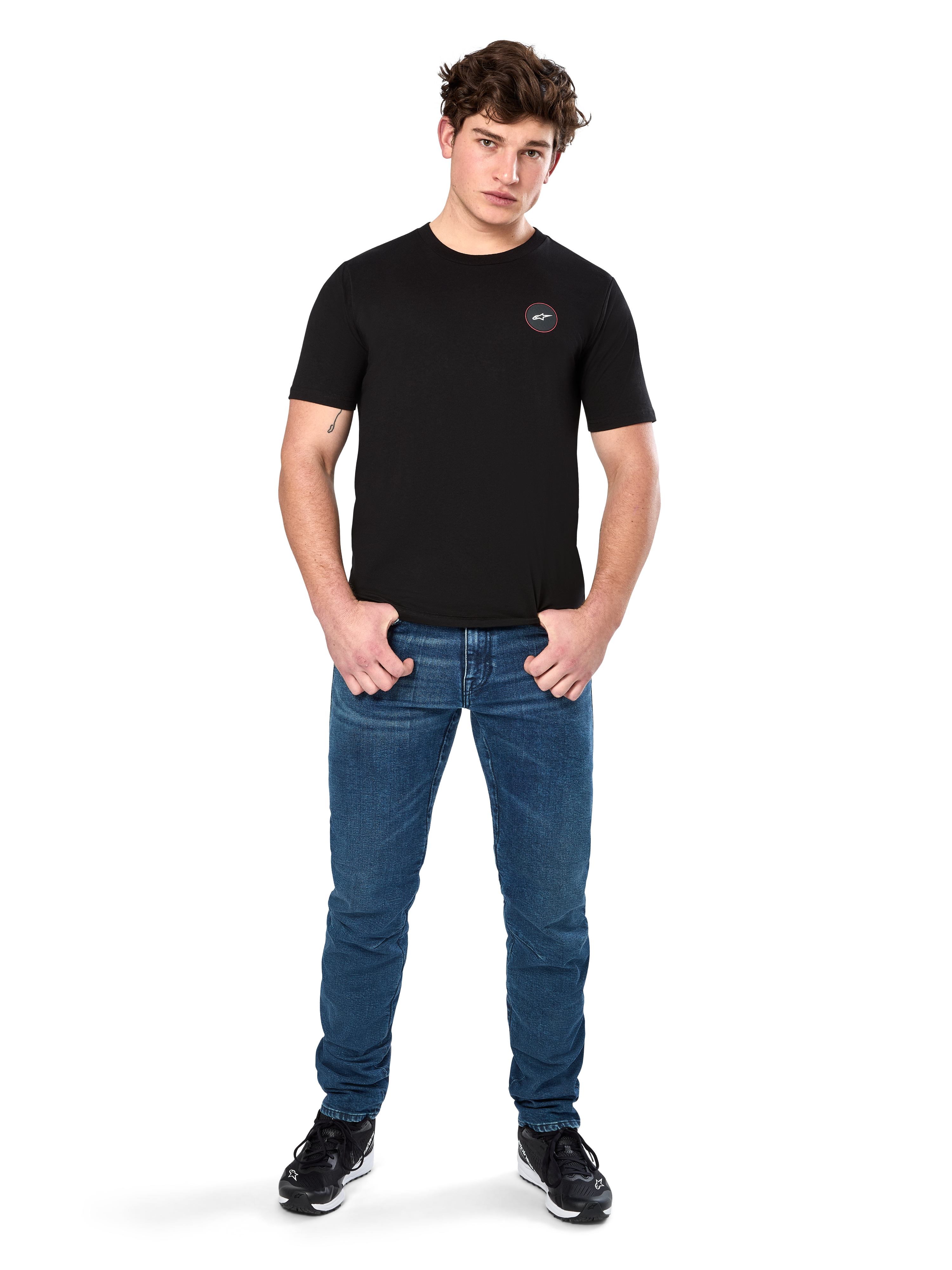 Alpinestars Dot Carbon CSF Tee, Short Sleeve T-Shirt, Black, Small Circular Astars Dot Logo on Chest, worn with blue jeans and black sneakers, casual motorsport streetwear
