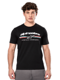 Alpinestars Prevail CSF Tee, t-shirt noir à manches courtes porté par un mannequin, avec logo blanc, bande tricolore et graphisme « PREMIUM RACEWEAR », streetwear décontracté inspiré du sport automobile
