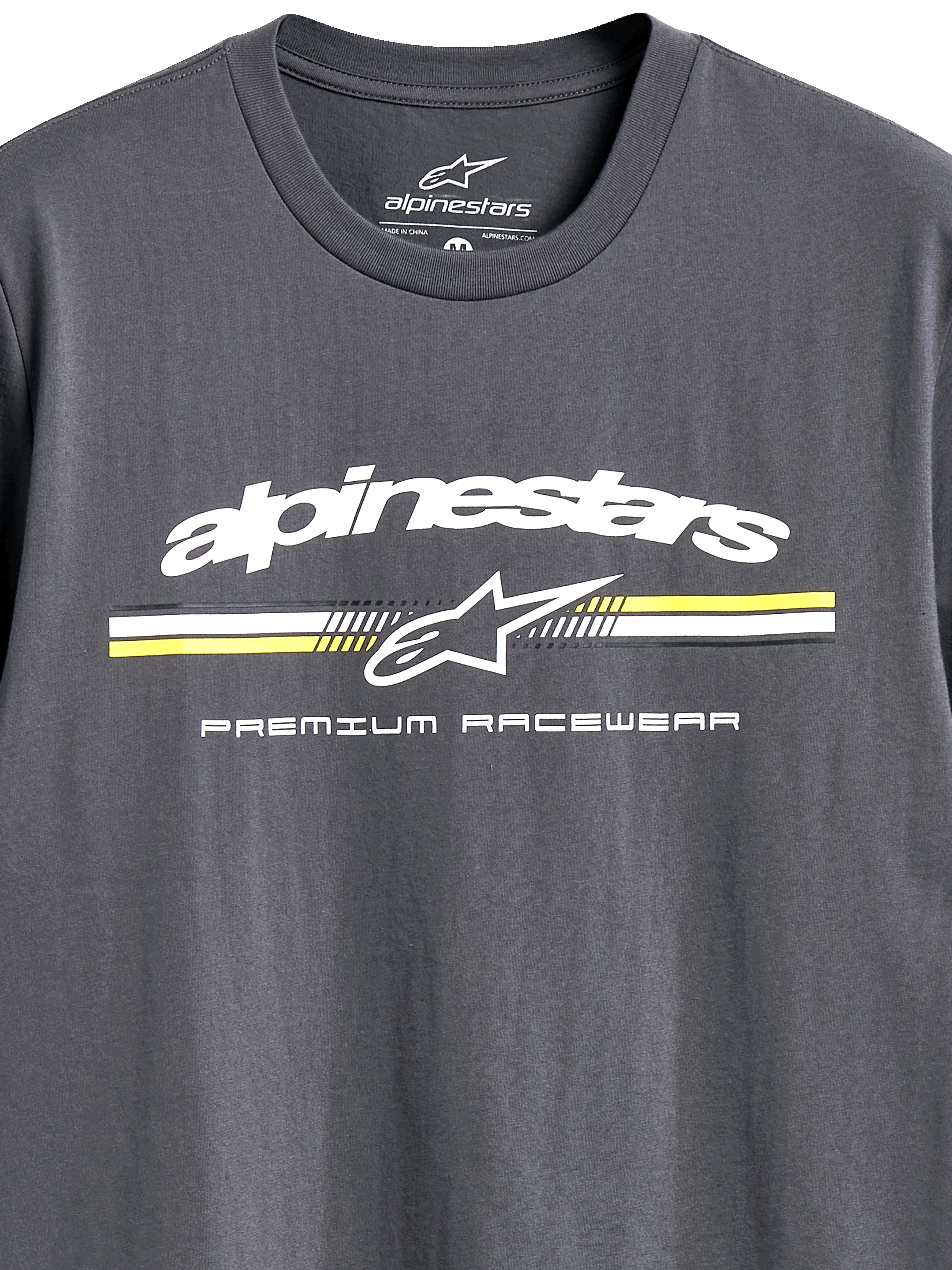 T-shirt Alpinestars Prevail CSF, t-shirt à manches courtes, gris anthracite, logo Alpinestars blanc avec rayures de style paddock jaunes et blanches, texte « Premium Racewear », vêtement de sport automobile décontracté