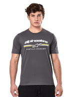 Alpinestars Prevail CSF Tee, t-shirt à manches courtes gris anthracite, logo Alpinestars blanc avec rayures jaunes et blanches et graphisme 'Premium Racewear', streetwear décontracté inspiré des sports mécaniques