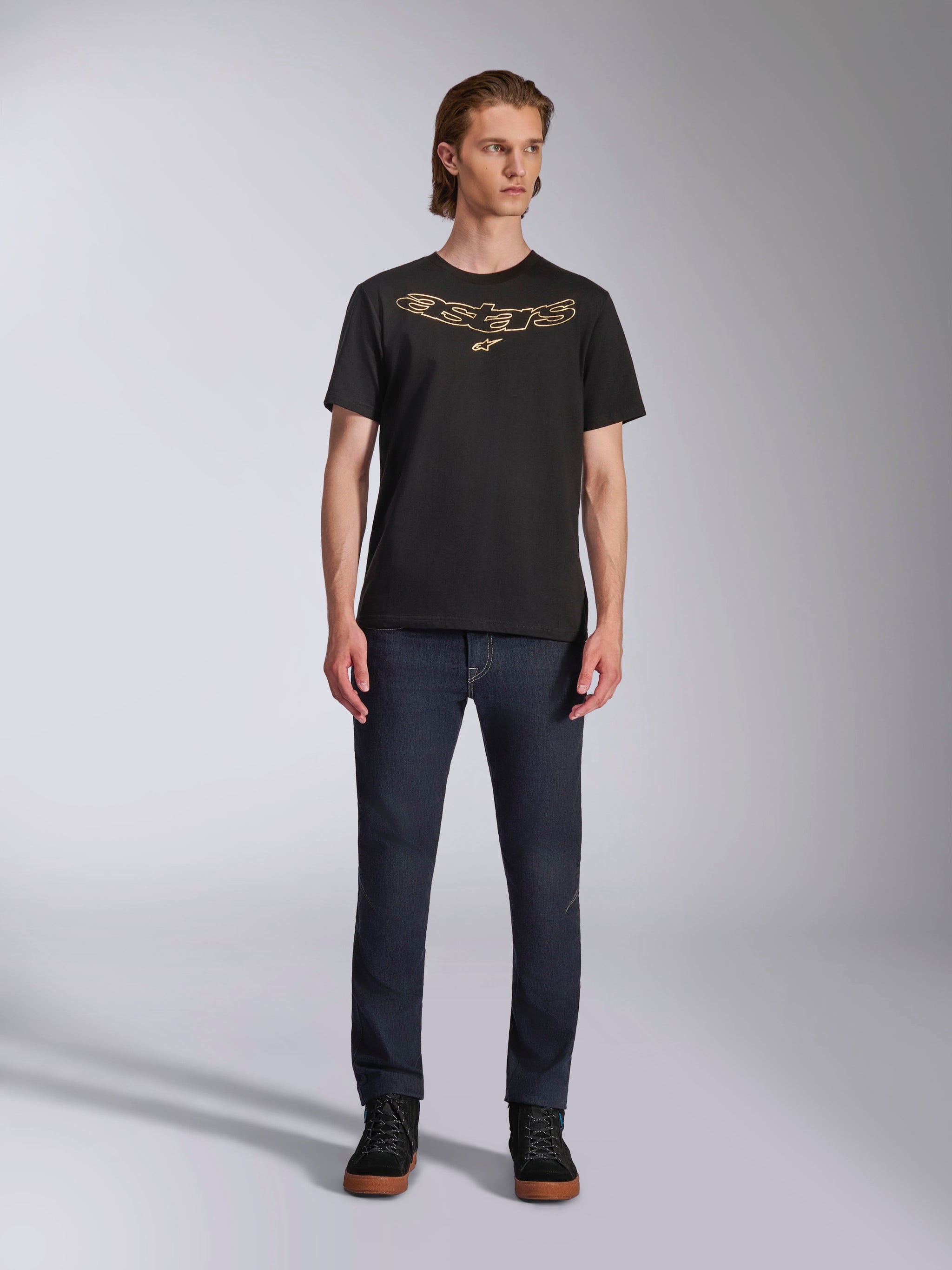 Alpinestars Luxo CSF Tee, Short Sleeve T-Shirt, Black, Tan outlined Astars chest logo, worn by model with dark denim jeans and black high-top shoes, Casual Motorsport Streetwear