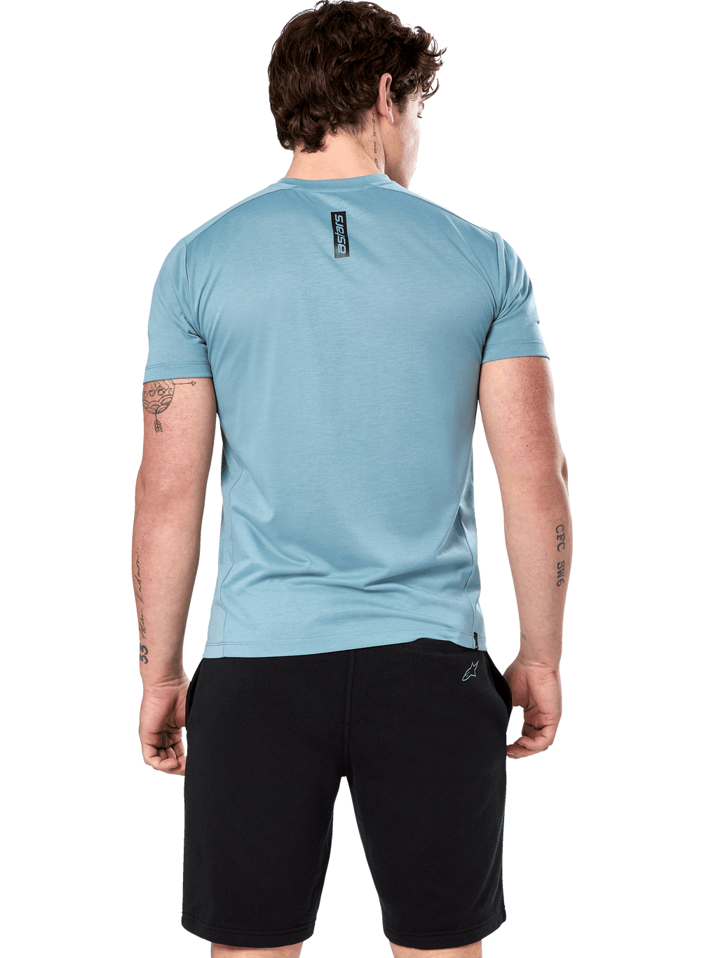 T-shirt Performance Point Alpinestars, t-shirt à manches courtes, bleu glacé, vue de dos sur mannequin montrant l'imprimé vertical noir astars, associé à un short noir, vêtement de sport de performance décontracté