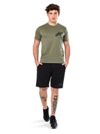 T-shirt Alpinestars Attrition Performance, t-shirt à manches courtes, vert clair, avec logo Astars noir sur la poitrine, porté avec un short de sport noir et des baskets noires, cliché lifestyle sportswear performance décontracté