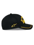 Casquette Alpinestars Luminary, casquette snapback noire, vue de profil, visière incurvée avec finition sutache jaune, logo brodé en 3D et étoile latérale jaunes, sergé 100 % coton, accessoire décontracté inspiré des sports mécaniques