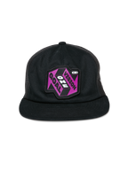 Casquette Trucker Alpinestars That Way, casquette trucker noire, dotée d'un écusson graphique violet et noir avec le texte « One Vision One Goal », visière plate, couronne structurée et panneaux arrière en mesh, couvre-chef décontracté inspiré des sports mécaniques