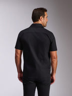 Chemise Strive Woven Alpinestars, chemise à manches courtes boutonnée noire, vue arrière montrant l'empiècement dos et la coupe ajustée, streetwear décontracté inspiré du motorsport