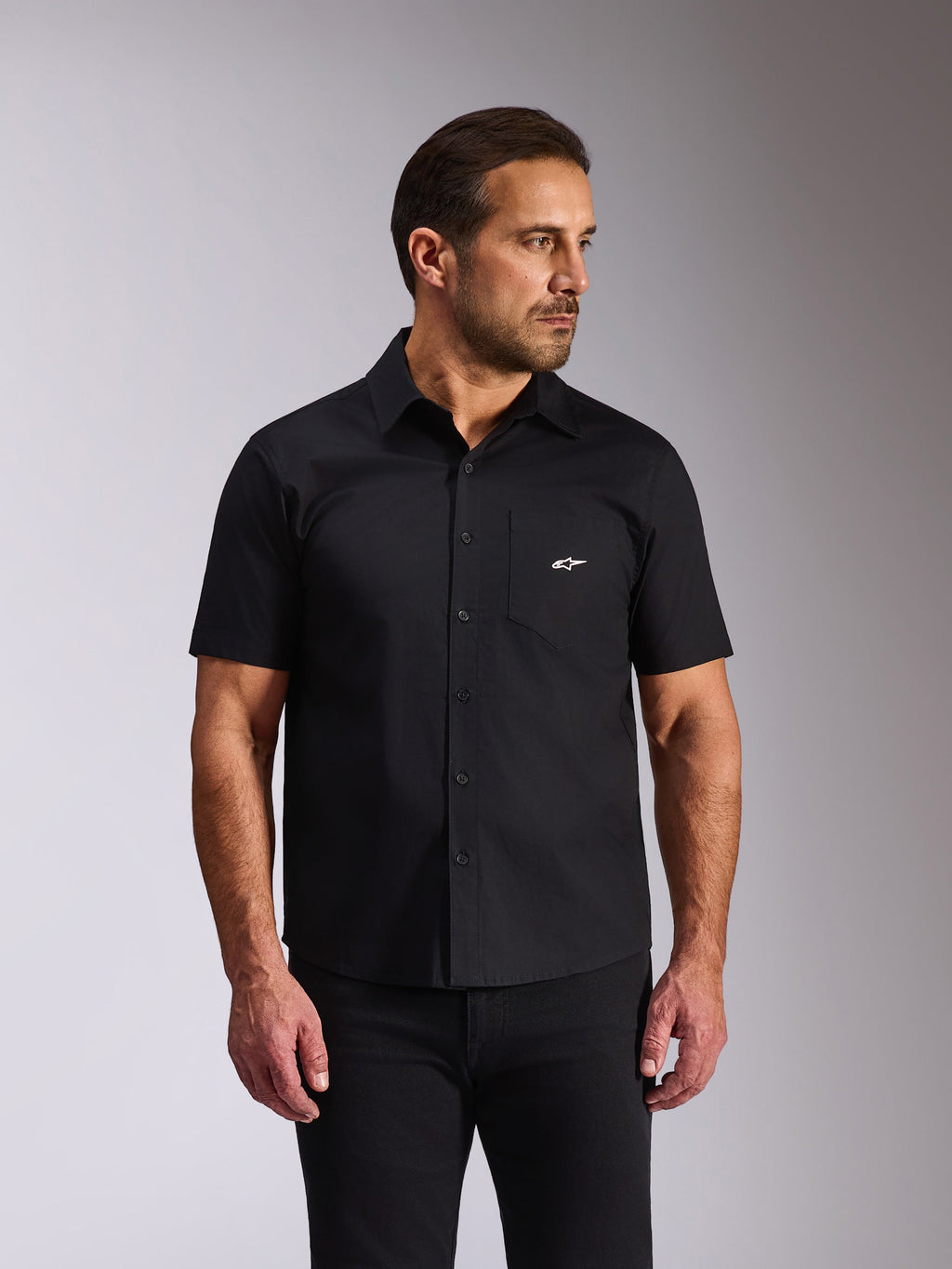 Chemise Alpinestars Strive Woven, chemise boutonnée à manches courtes, noire, logo Alpinestars blanc sur la poche poitrine, style streetwear décontracté motorsport