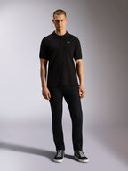 Alpinestars Endeavor Classic Polo, Short Sleeve Pique Polo Shirt, Black, small white Astars logo on chest, ribbed collar and cuffs, worn by model with black pants and sneakers, casual motorsport streetwear