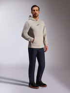 Sweat à capuche Insight Alpinestars, streetwear décontracté, gris ciment avec logo Astars noir sur la poitrine, design à enfiler avec poche kangourou, porté avec un jean bleu foncé et des baskets noires, style moderne inspiré du sport automobile