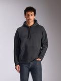 Alpinestars Emergent Oversized Hoodie, noir, mannequin masculin portant un sweat à capuche en polaire de coupe ample, logo Astars brodé en 3D ton sur ton, poche kangourou, capuche à cordon de serrage, streetwear décontracté inspiré du sport automobile