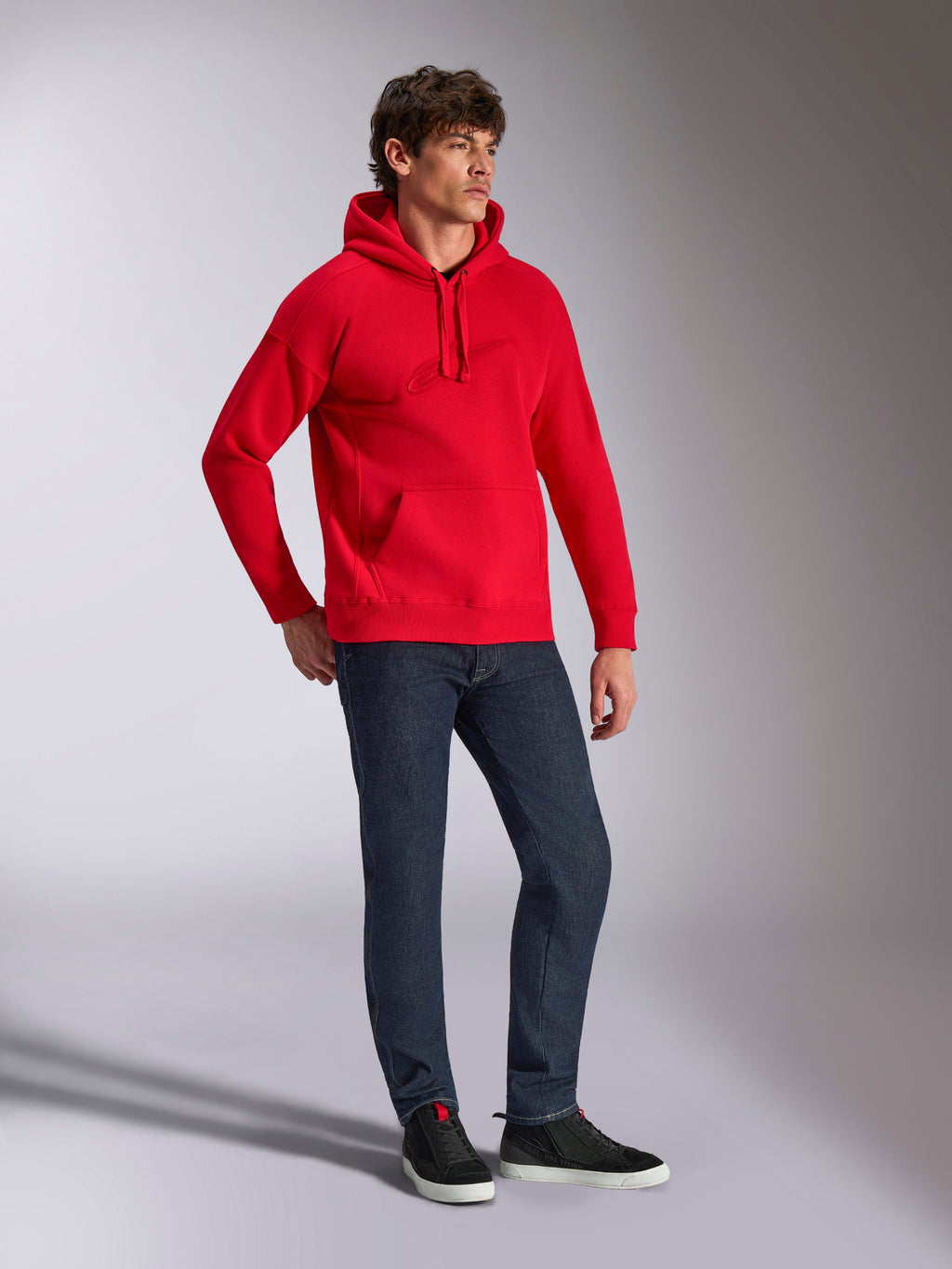 Alpinestars Emergent Oversized Hoodie, Red, pullover fleece hoodie with tonal 3D embroidered logo, oversized fit, worn by a model with dark blue jeans and black sneakers, casual motorsport-inspired streetwear