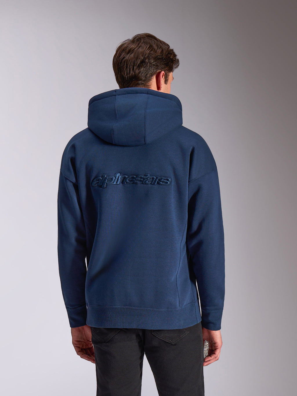 Sweat à capuche Alpinestars Emergent Oversized, bleu marine, vue de dos avec logo Alpinestars brodé ton sur ton, coupe ample en polaire, capuche à cordon de serrage et poignets côtelés, streetwear d'inspiration sport automobile