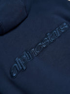 Sweat à capuche Alpinestars Emergent Oversized, Bleu Marine, gros plan sur le logo Alpinestars en broderie 3D ton sur ton au dos, texture polaire premium