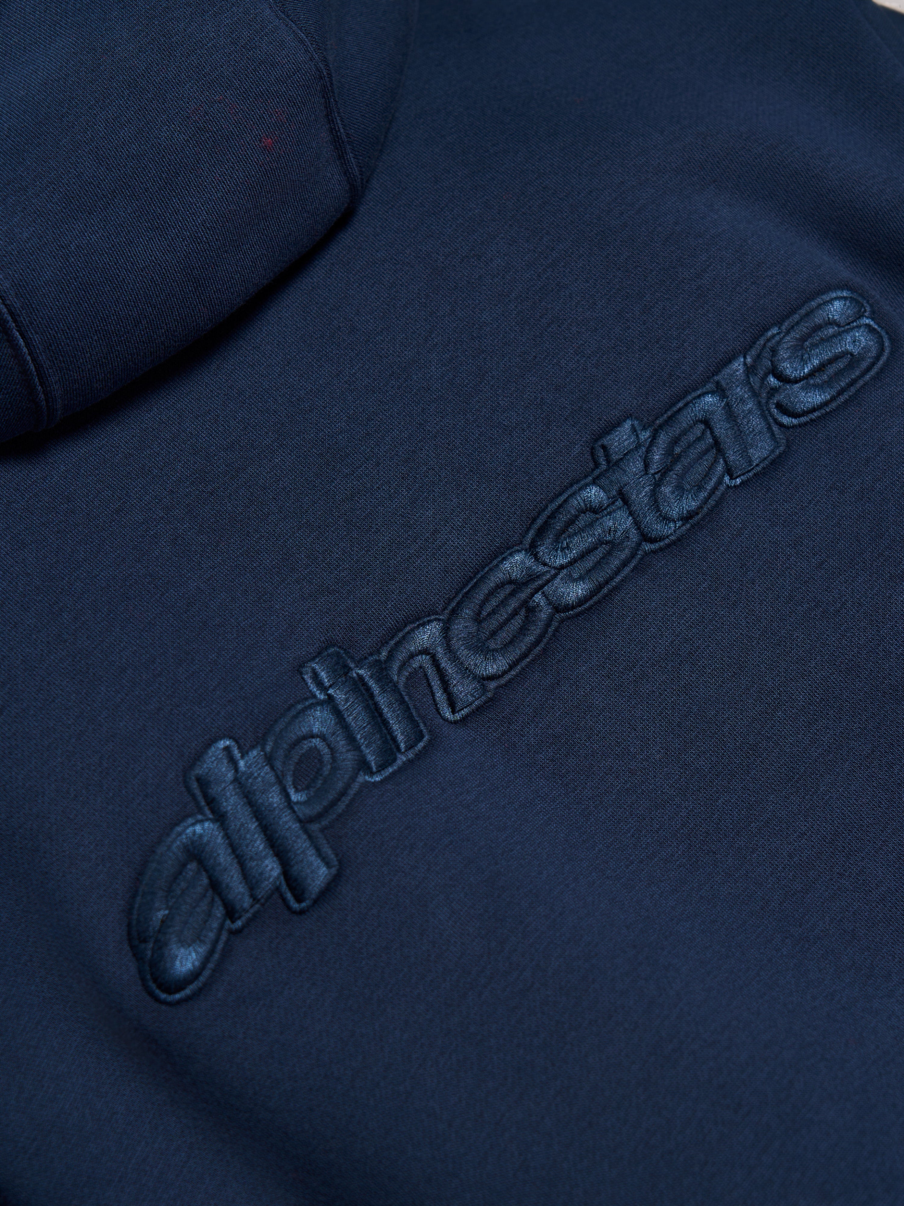 Sweat à capuche Alpinestars Emergent Oversized, Bleu Marine, gros plan sur le logo Alpinestars en broderie 3D ton sur ton au dos, texture polaire premium