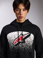 Alpinestars Obsessed Hoodie, sweat à capuche en polaire noire, logo Astars rouge et blanc dans un graphisme en dégradé MX pointillé blanc sur la poitrine, porté par un mannequin, streetwear décontracté avec capuche à cordon de serrage ajustable