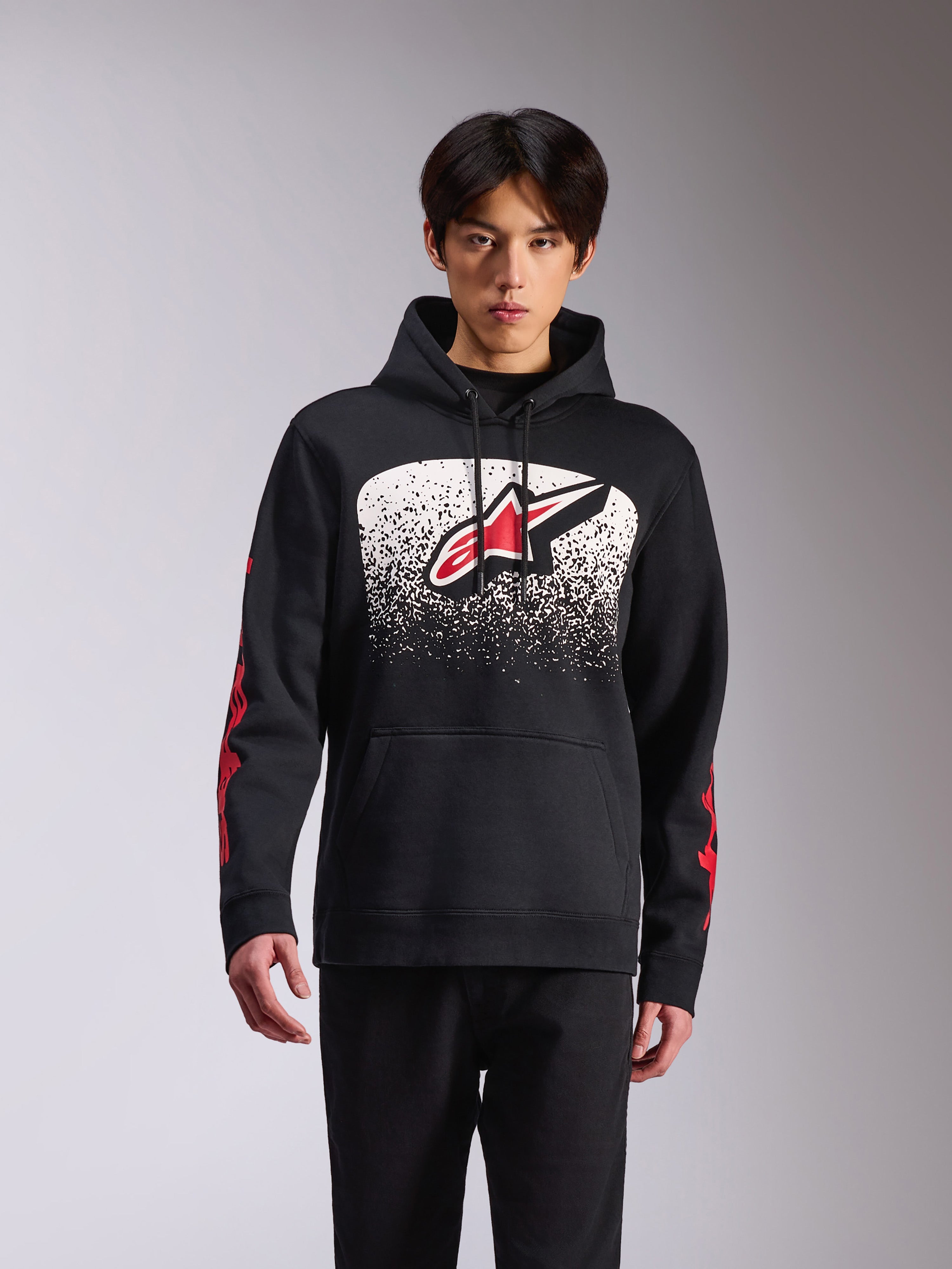 Alpinestars Obsessed Hoodie, sportswear décontracté, sweat à capuche noir arborant un grand logo Astars sur le devant avec un dégradé MX moucheté blanc et noir, marquage rouge sur les manches, capuche à cordon de serrage et poignets côtelés