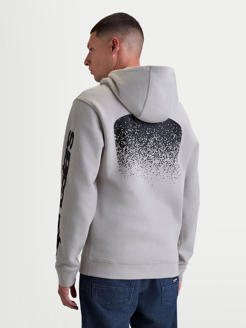 Alpinestars sweat à capuche Obsessed, polaire de sportswear pour homme, gris ciment et noir, doté d'un graphisme dégradé au dos inspiré du MX et de logos sur les manches, vue de dos sur modèle, style sportswear décontracté.