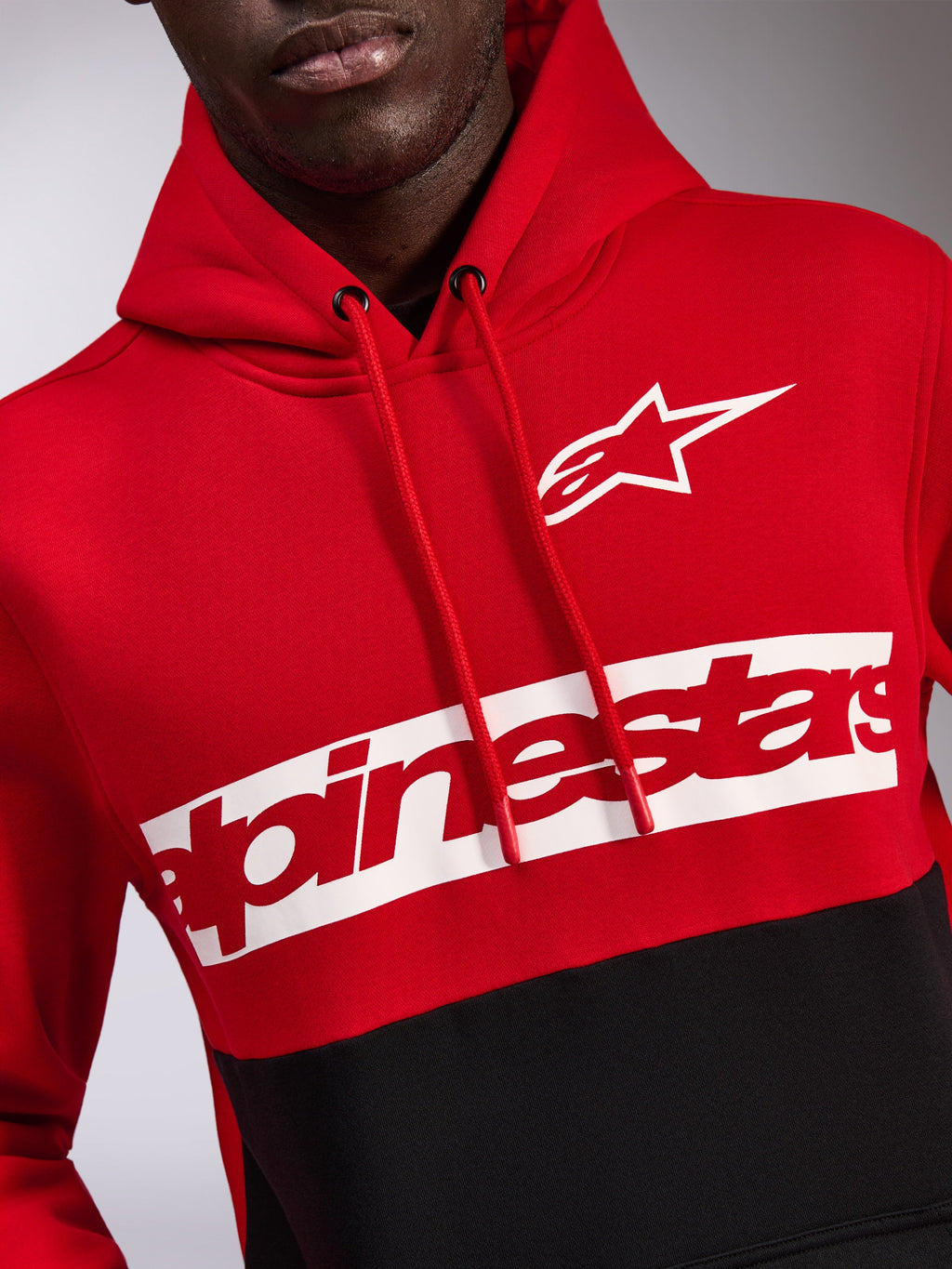 Sweat à capuche Alpinestars Parallel, polaire avec blocs de couleurs rouge et noir, orné d'un logo Astars blanc et d'un logo Alpinestars rouge sur une bande blanche sur la poitrine, capuche avec cordon de serrage, vêtement streetwear décontracté inspiré du sport automobile