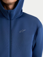 Alpinestars Cypher Hoodie, sweat à capuche sportswear zippé pour homme et femme, bleu acier, polaire technique double face avec capuche à col haut et logo Astars, vue rapprochée sur modèle