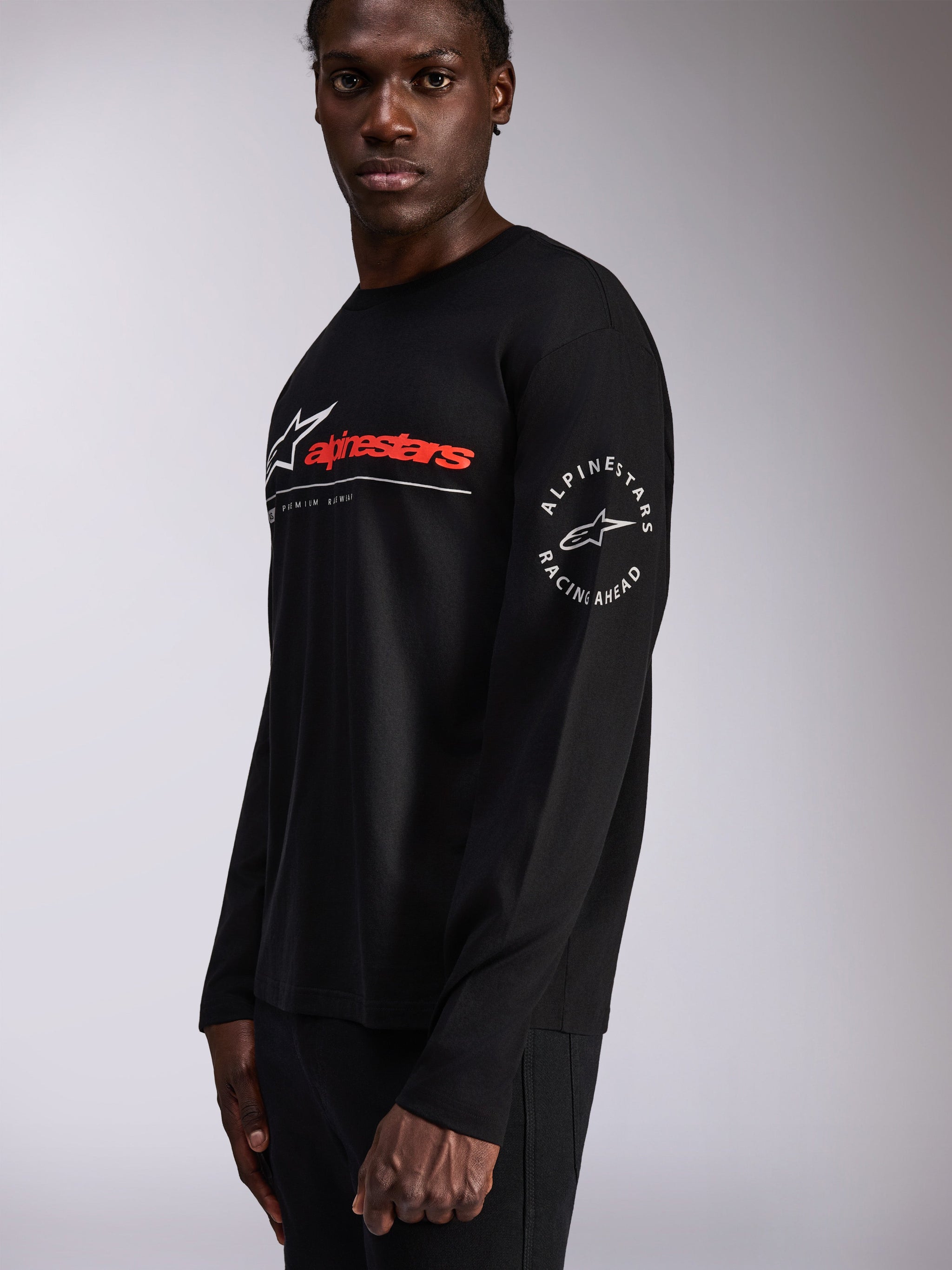Alpinestars Mandatory CSF Tee, Long Sleeve T-Shirt, Black, Red and White Alpinestars wordmark on chest, Circular Star logo on the sleeve, casual motorsport streetwear worn by a model