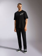 T-shirt Alpinestars One Oversized CSF, t-shirt à manches courtes, noir, logo Astars blanc sur la poitrine, coupe surdimensionnée, porté par un mannequin avec un pantalon noir et des baskets, style streetwear décontracté